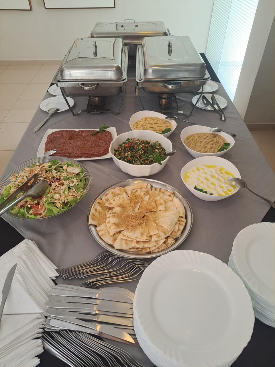 Homus, babaghanouj, kibe cru, tabule e coalhada seca servidos em travessas