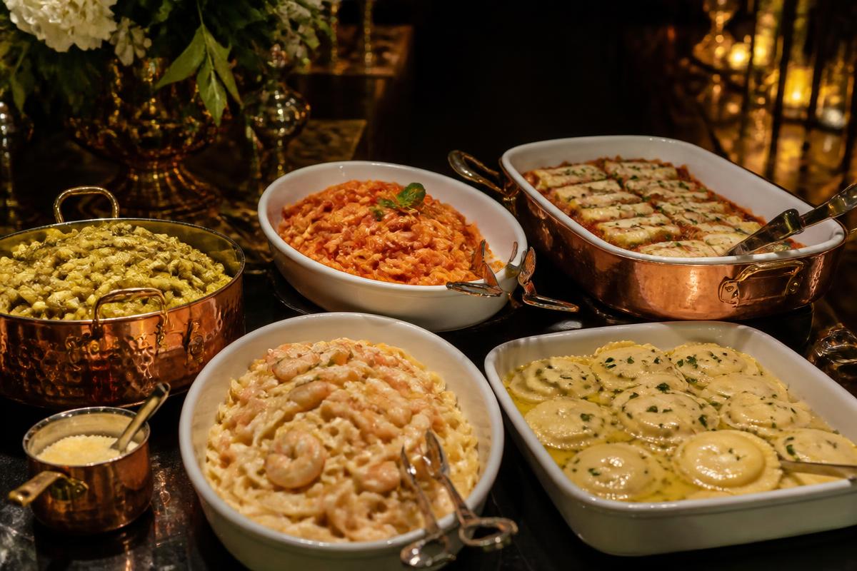 Buffet de massas frescas com molhos, ravióli e fettuccine em travessas